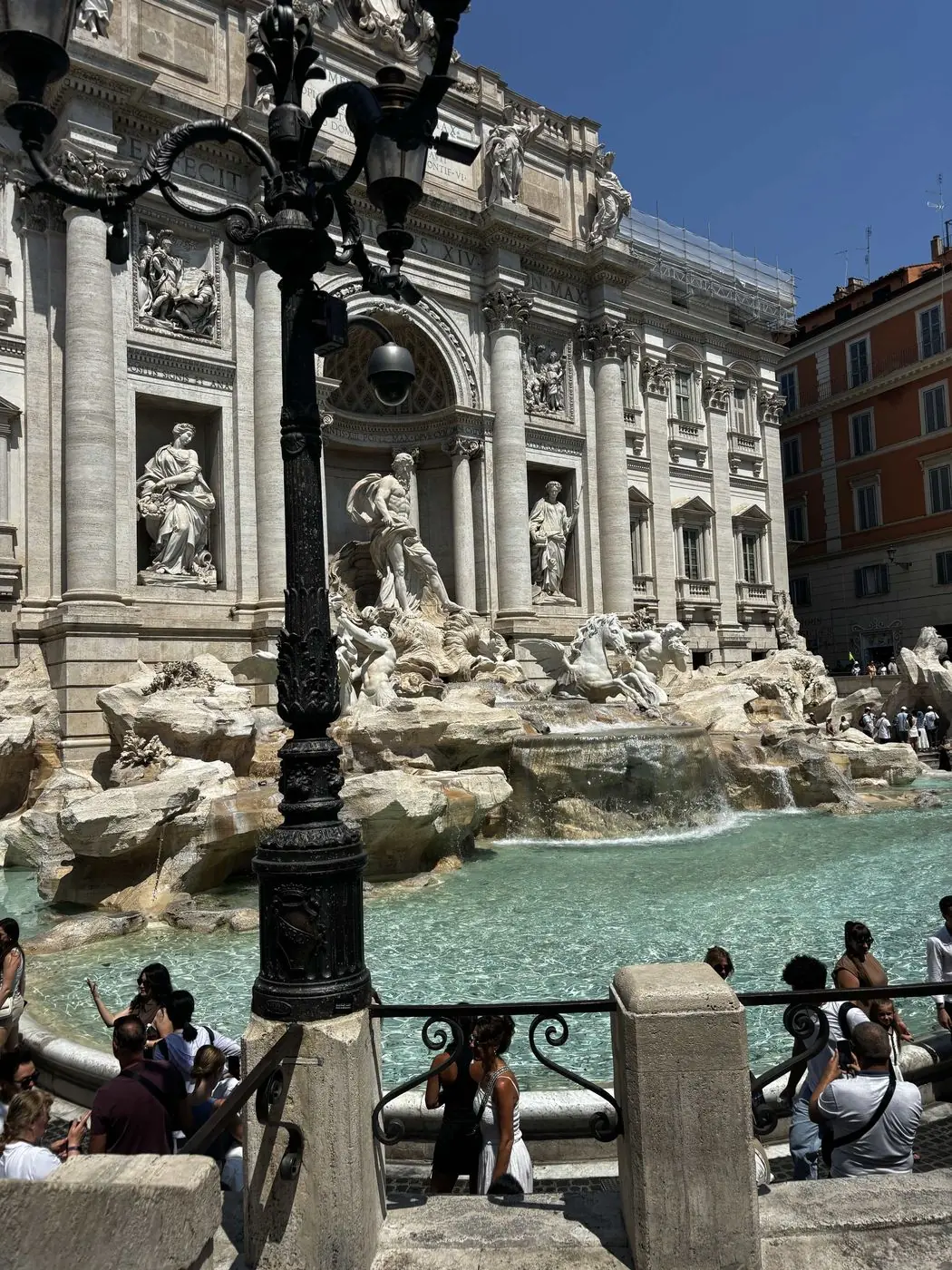 The Trevi Fountain in Rome, its sculptures and turquoise basin crowded with visitors